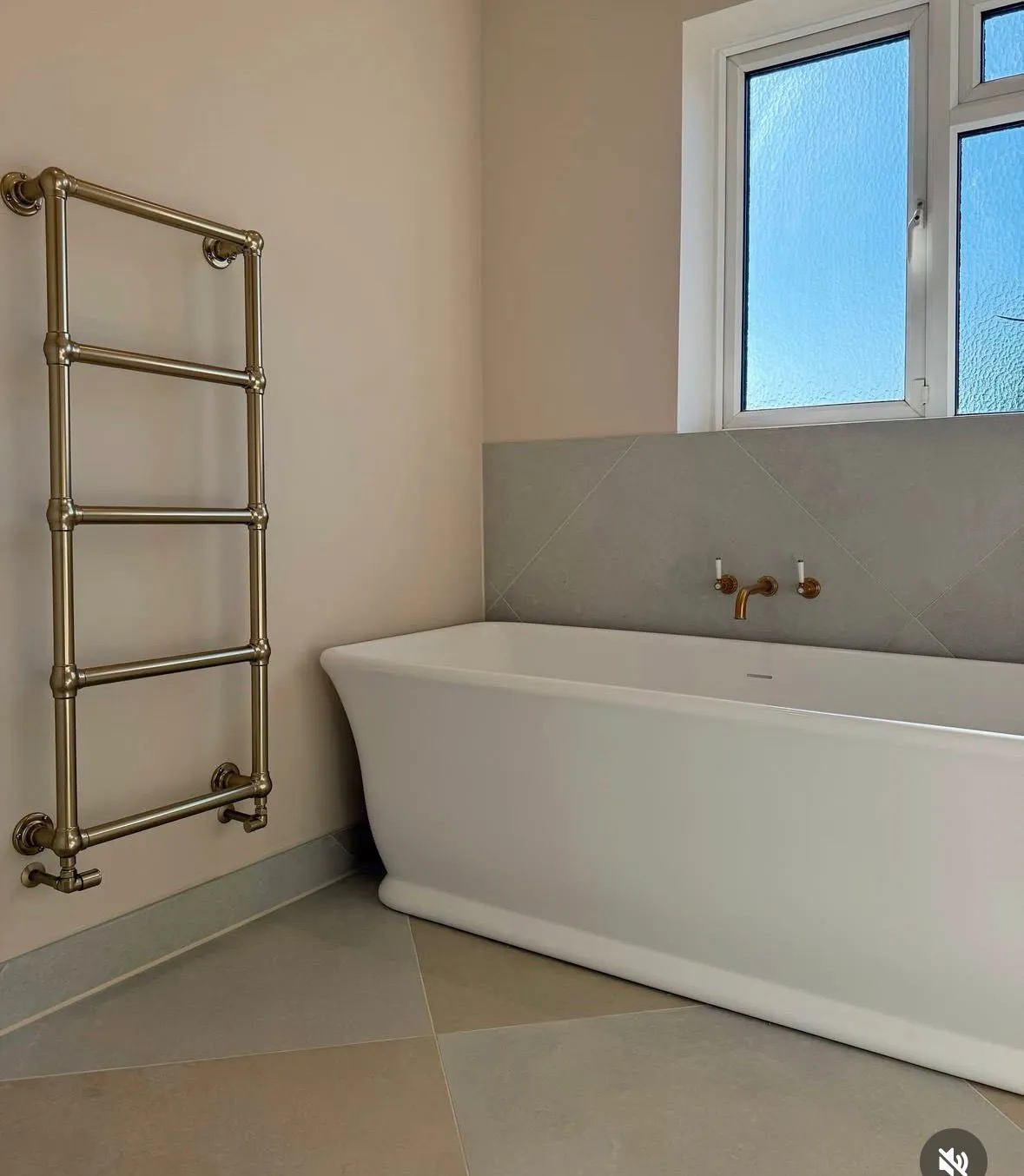 Freshly painted modern bathroom with a white freestanding tub and gold towel rail