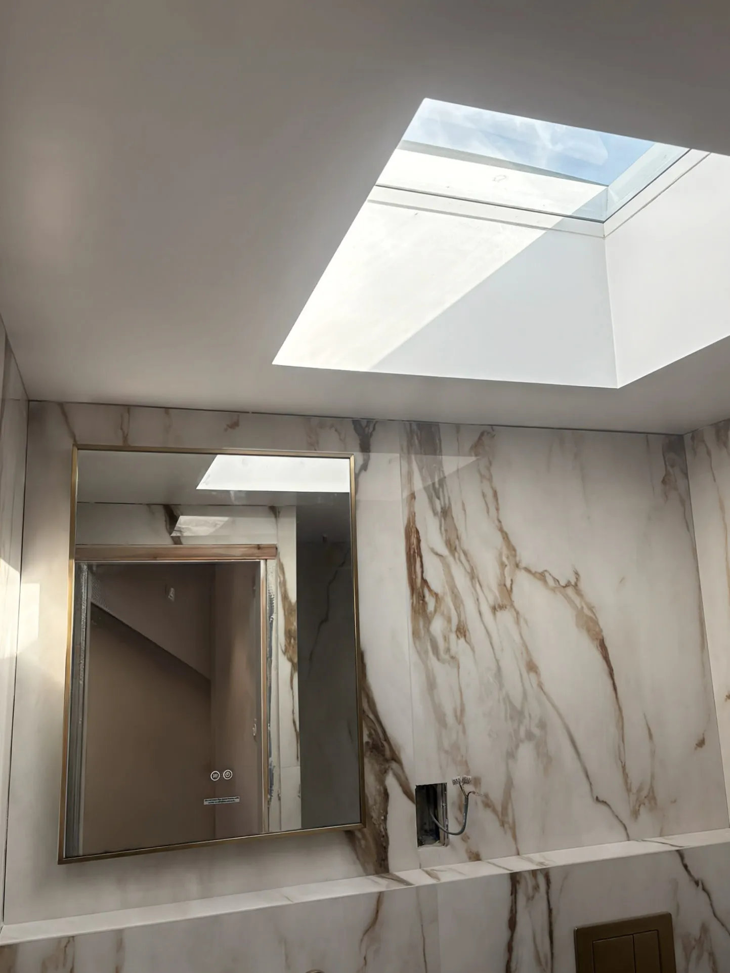 Modern bathroom skylight and marble tiling painted by professionals in Essex