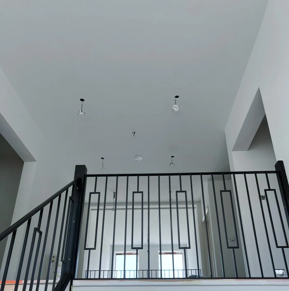 Flawless white painted landing and ceiling with black staircase railing